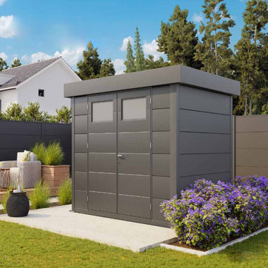 Telluria Sustainable Eleganto Steel Shed in Anthracite. Outside front right view of building in situ in a garden, showing pent roof and double opening front doors with windows. 10x10.