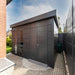 Telluria Sustainable Eleganto Premier Steel Shed in Anthracite. Outside view of front right hand side, showing pent roof and front double doors and double floor to ceiling windows. In Situ in garden. Please note this building comes with windows in the doors as standard (see other images).