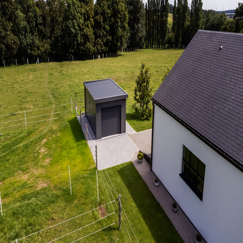 Telluria Sustainable Eleganto Garage in Anthracite. Outside birdseye view showing the roof, front and left of garage in situ, next to a house giving good idea of size, look and feel. 