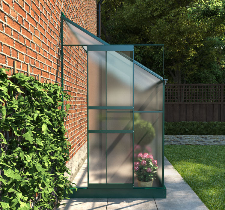 Small Space Metal and Polycarbonate Lean-To Greenhouse. Front outside view with door partly open, situated in a garden attached to a house.