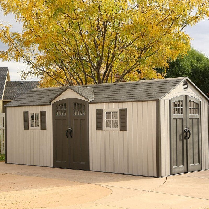 Lifetime 20' Cottage Style Plastic Shed, Dual Entrance, front and right view of building showing the two entrances with double doors and 2 windows with shutters. In situ in an outside space.