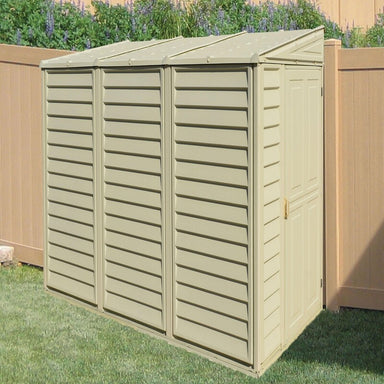 Saffron Lean-To Vinyl Shed with Foundation Kit mounted to a fence on the right. Front right view showing slatted side and roof with front door shut.